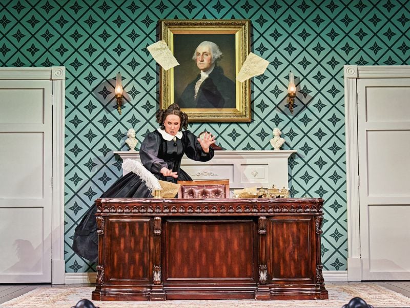 Catherine Tate in Oh, Mary! as Mary Todd Lincoln. She throws papers into the air as she goes through a wooden brown desk.