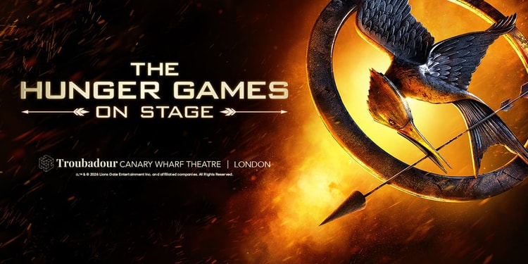 The Hunger Games on stage logo, featuring the words 'The Hunger Games' alongside the iconic mockingjay bird engulfed in flames.