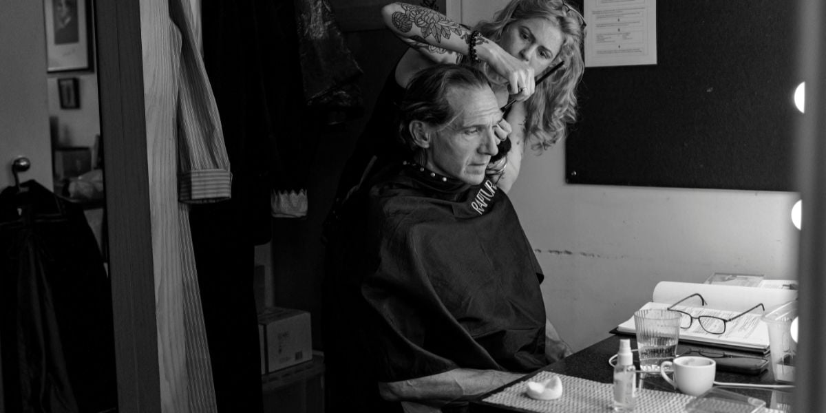 Grace Pervades behind the scenes photos, starring Ralph Fiennes and Miranda Raison. Ralph Fiennes is sat at his dresser whilst the makeup artist prepares him for the show.