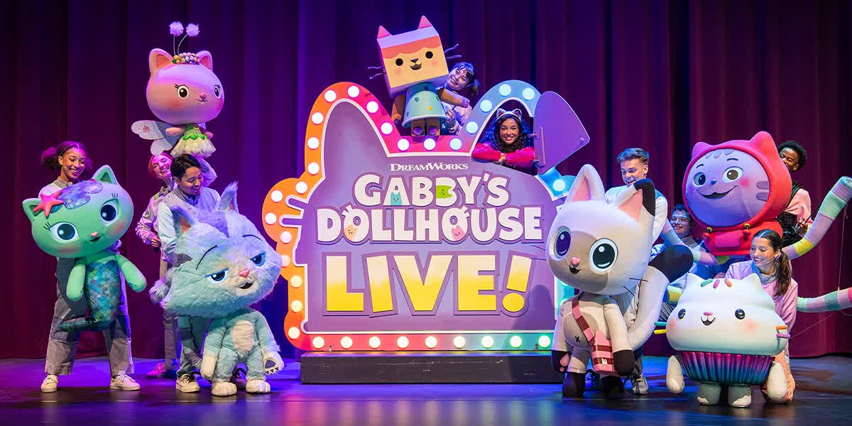 Gabby's Dollhouse Live! The main character Gabby is surrounded by seven performers with large puppet cats.
