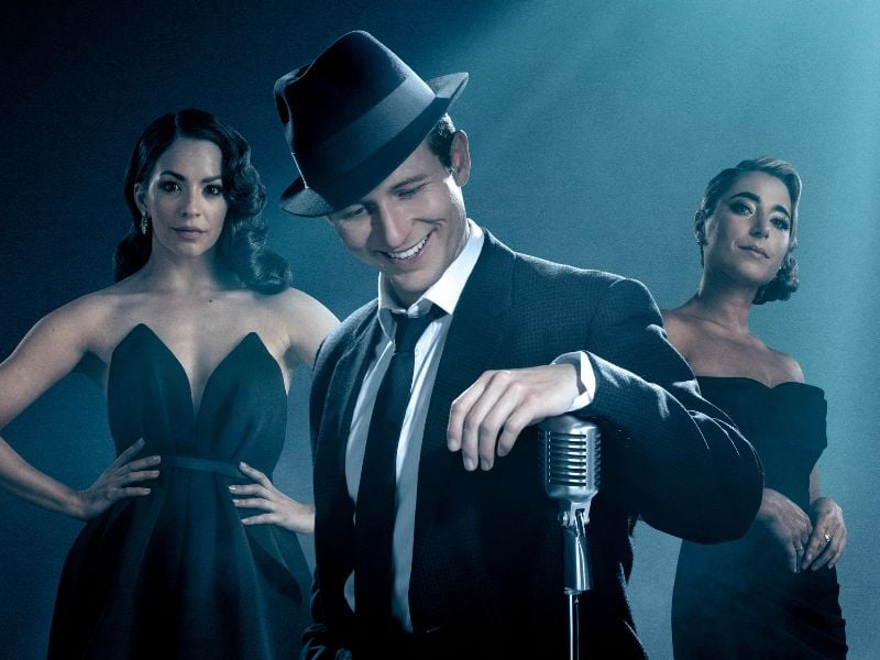 Joel Harper-Jackson as Frank Sinatra, wearing a suit and hat. To his left is Ana Villafañe as Ava Gardner and to his right Phoebe Panaretos as Nancy Sinatra.
