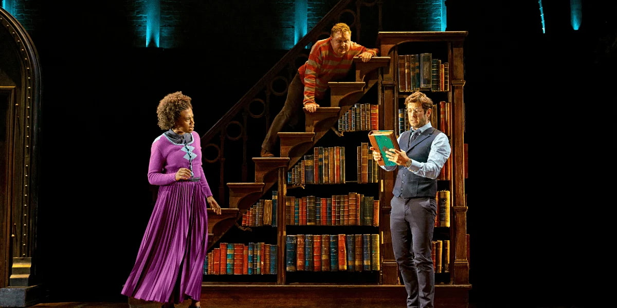 Harry Potter, Hermione Granger, and Ron Weasley stand in the library while reading a book Show: Harry Potter and the Cursed Child