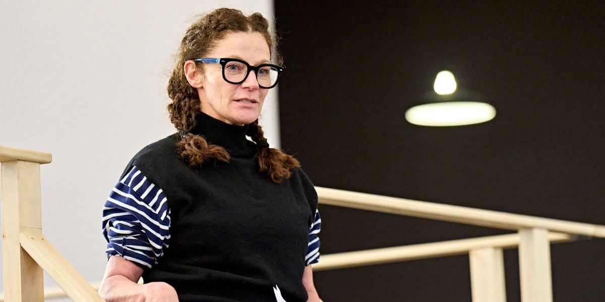Michelle Gomez wearing glasses stood at the top of some stairs at a rehearsal for One Flew Over the Cuckoo's Nest at the Old Vic.