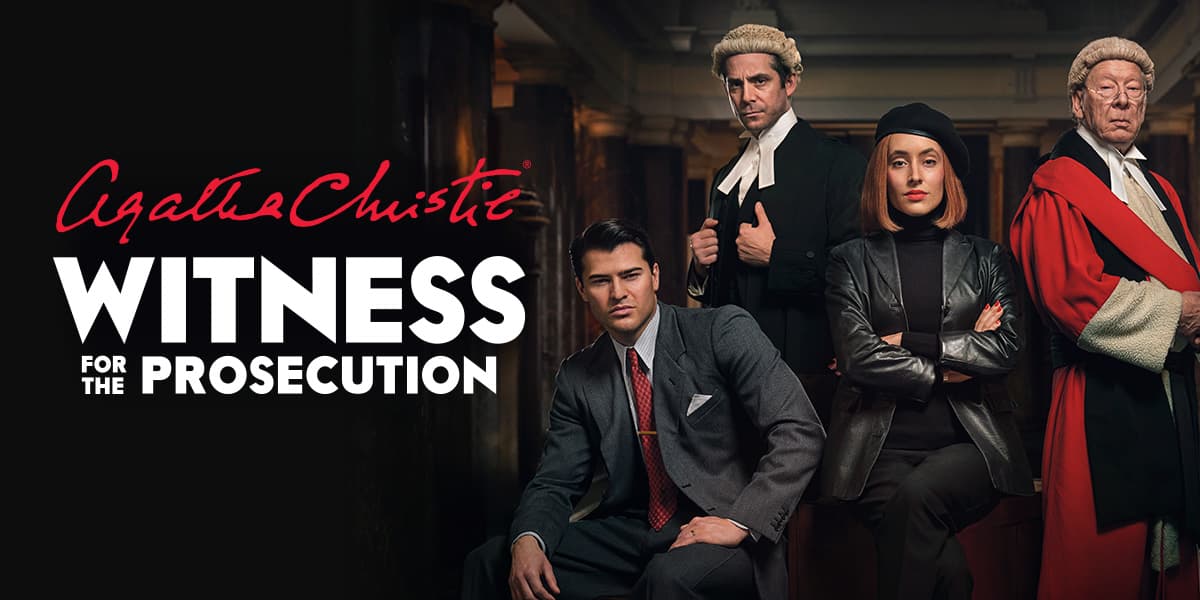 Four people stand behind text reading 'Agatha Christie Witness for the Prosecution'. Two are dressed as judges in wigs and robes, one is a woman dressed all in black, arms folded and the fourth is a man dressed in a suit.