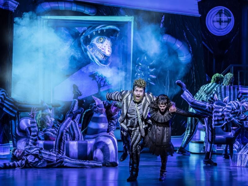 David Fynn as Beetlejuice and Hannah Nordberg as Lydia Deetz with the Company of Beetlejuice the Musical, West End © Johan Persson