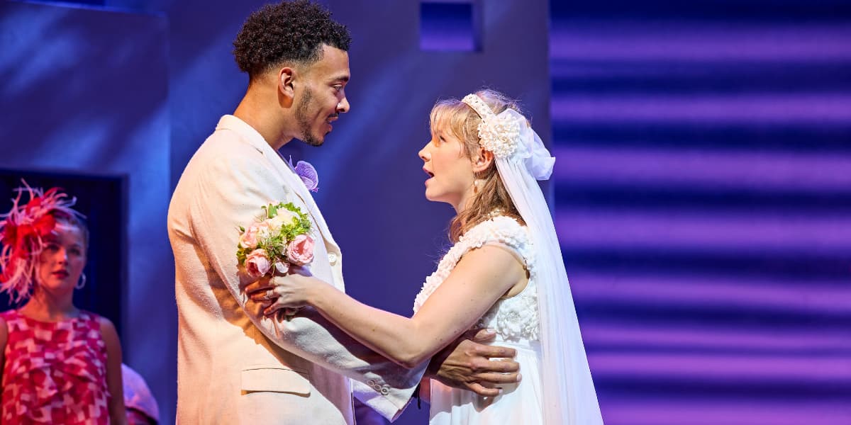 Sky and Sophie looking into each others eyes on their wedding day in MAMMA MIA!