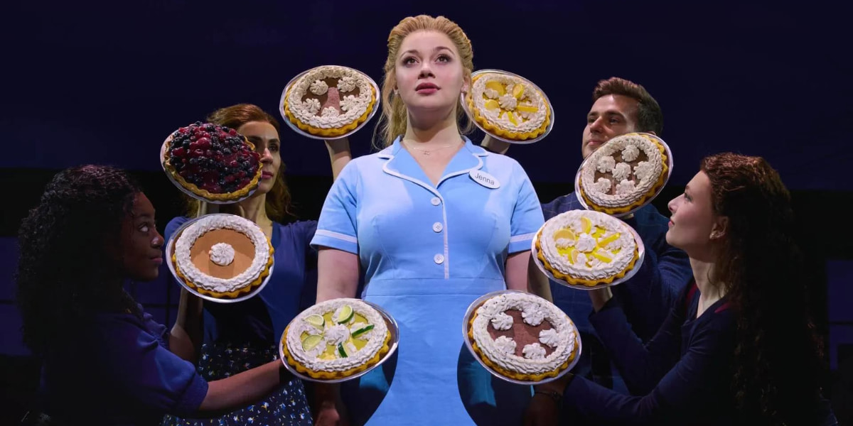 Carrie Hope Fletcher surrounded by pies in a production shot for the 10th anniversary tour for Waitress The Musical
