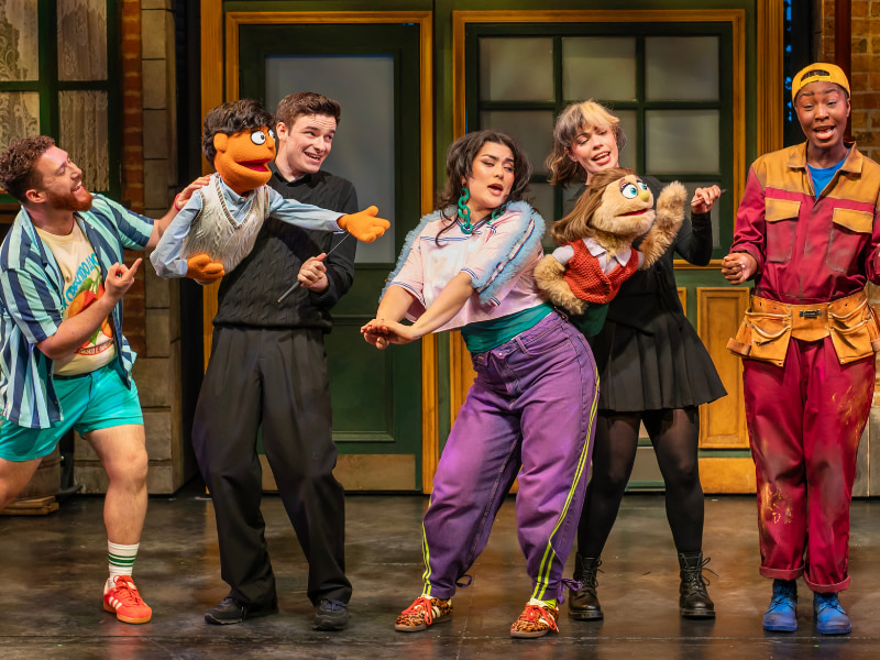 The cast of Avenue Q. From right to left: Oliver Jacobson (Brian), Noah Harrison (Princeton), Amelie Kinu Muss (Christmas Eve), Emily Benjamin (Kate Monster), Dionne Ward-Anderson (Gary Coleman). 
